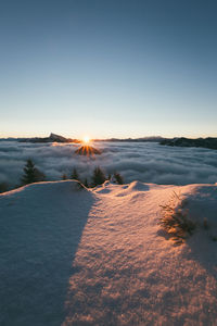 Scenic view of snowy landscape against sky during sunset