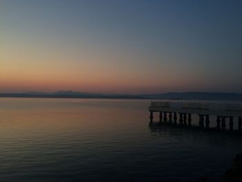 Scenic view of lake against clear sky at sunset