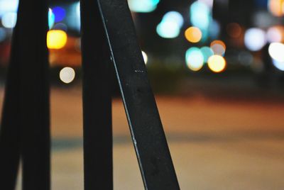 Close-up of illuminated lighting equipment on road at night