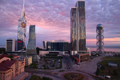 Modern buildings in city against cloudy sky