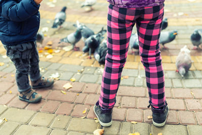 Low section of women standing on footpath