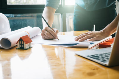 Midsection of woman using laptop on table