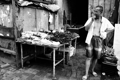 Full length of man eating food on market stall