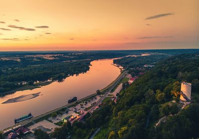 High angle view of cityscape by sea against sky during sunset