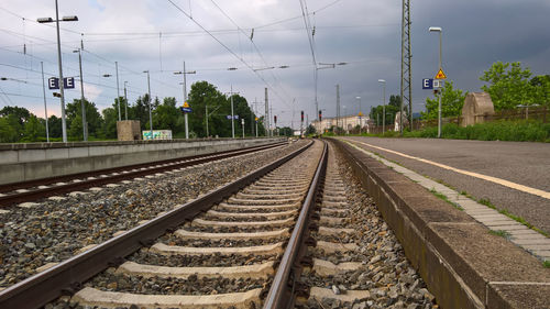 Railroad tracks by platform against sky