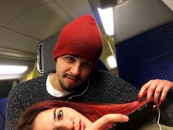 Portrait of couple listening music while traveling in airplane