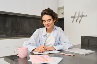 Portrait of young businesswoman working at table