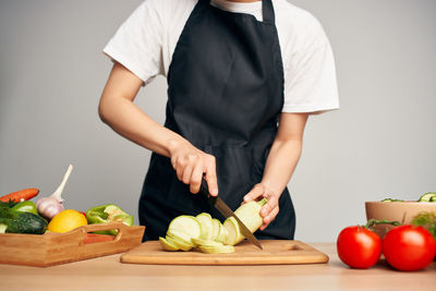 Midsection of man holding fruits and vegetables on cutting board