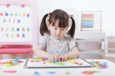 Young girl playing creative toy blocks for homeschooling