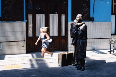 Statue of woman walking in city