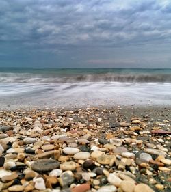 View of pebbles on beach against sky