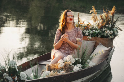 Portrait of young woman sitting on boat in lake