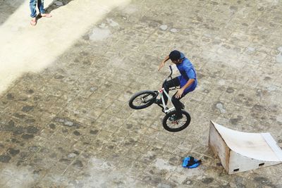 Man performing stunt with bicycle on footpath