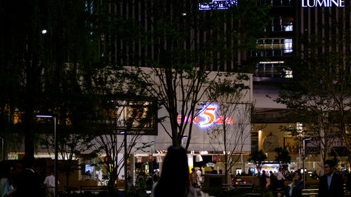 Woman walking on illuminated city street