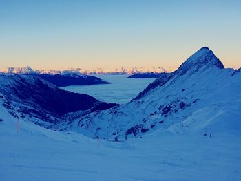 Scenic view of snow covered mountain against blue sky