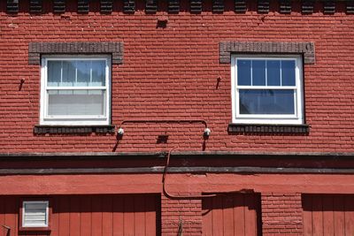 Low angle view of red window on brick wall of building
