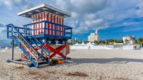 Lifeguard hut on beach against sky in city