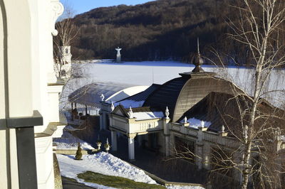 Snow covered houses by buildings against mountain