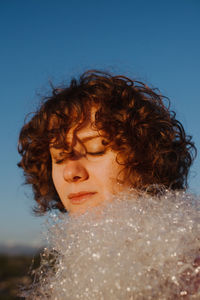 Woman with plastic against blue sky