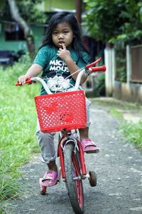 Portrait of young woman riding bicycle on road