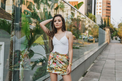 Beautiful young woman standing in front of house