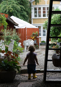 Rear view of girl standing in yard