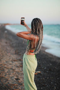 Woman photographing at beach