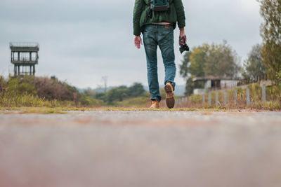 Rear view of man walking on footpath
