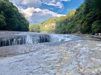 Scenic view of waterfall against sky