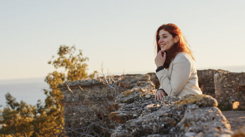 Beautiful girl with white dress explores an ancient italian castle at sunset