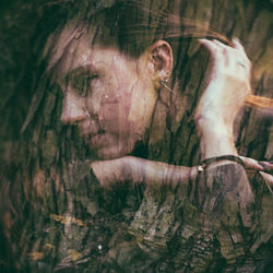 Portrait of woman with tree trunk in forest