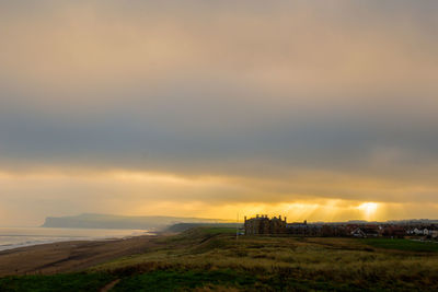 Scenic view of land against sky during sunset