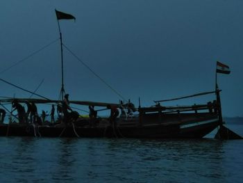 People fishing in sea against clear sky