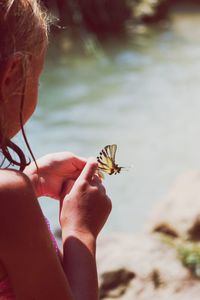 Close-up of girl holding butterfly
