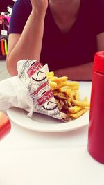 Midsection of person eating food on table at restaurant