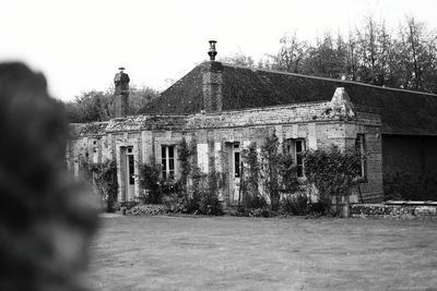 Exterior of old building by trees against sky