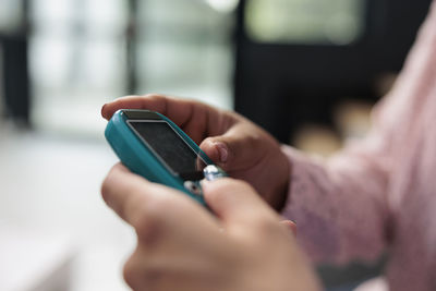 Cropped hand using mobile phone