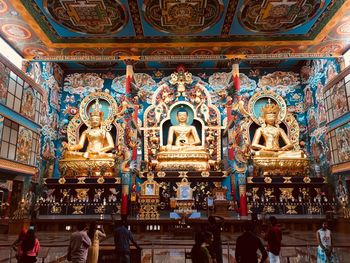 Low angle view of people in front of statues at temple