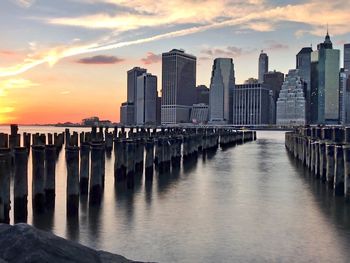 View of pier over river against cloudy sky during sunset