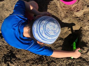 High angle view of boy wearing hat on sand