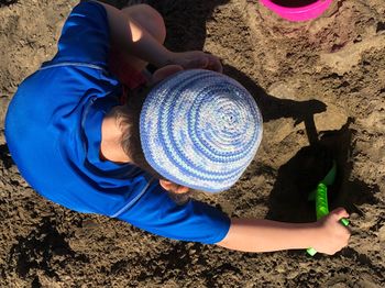 Directly above shot of boy playing on sand at beach