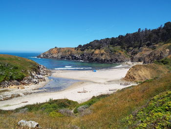 Scenic view of beach against clear blue sky