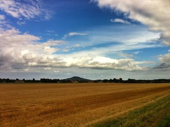 Scenic view of field against cloudy sky