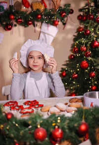 Portrait of smiling young woman holding christmas tree