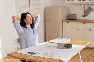 Tired businesswoman sitting on desk at home