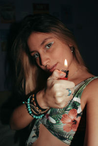 Portrait of young woman holding a lighter 