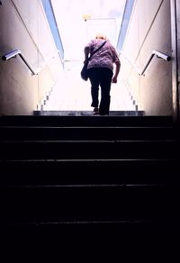 Rear view of man standing on staircase
