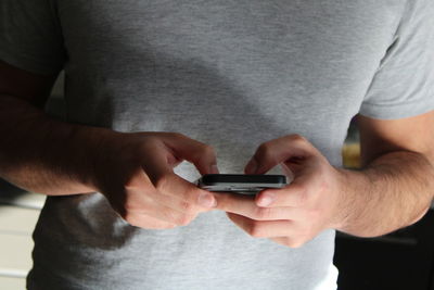 Midsection of man using mobile phone