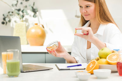 Portrait of young woman using mobile phone on table