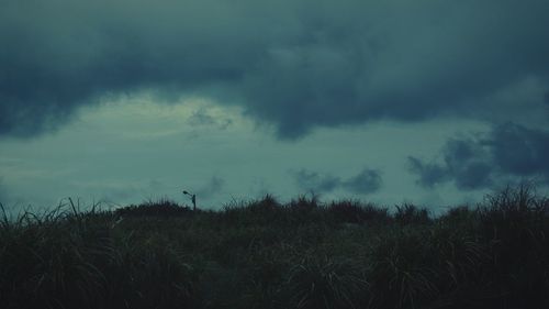 Scenic view of field against cloudy sky